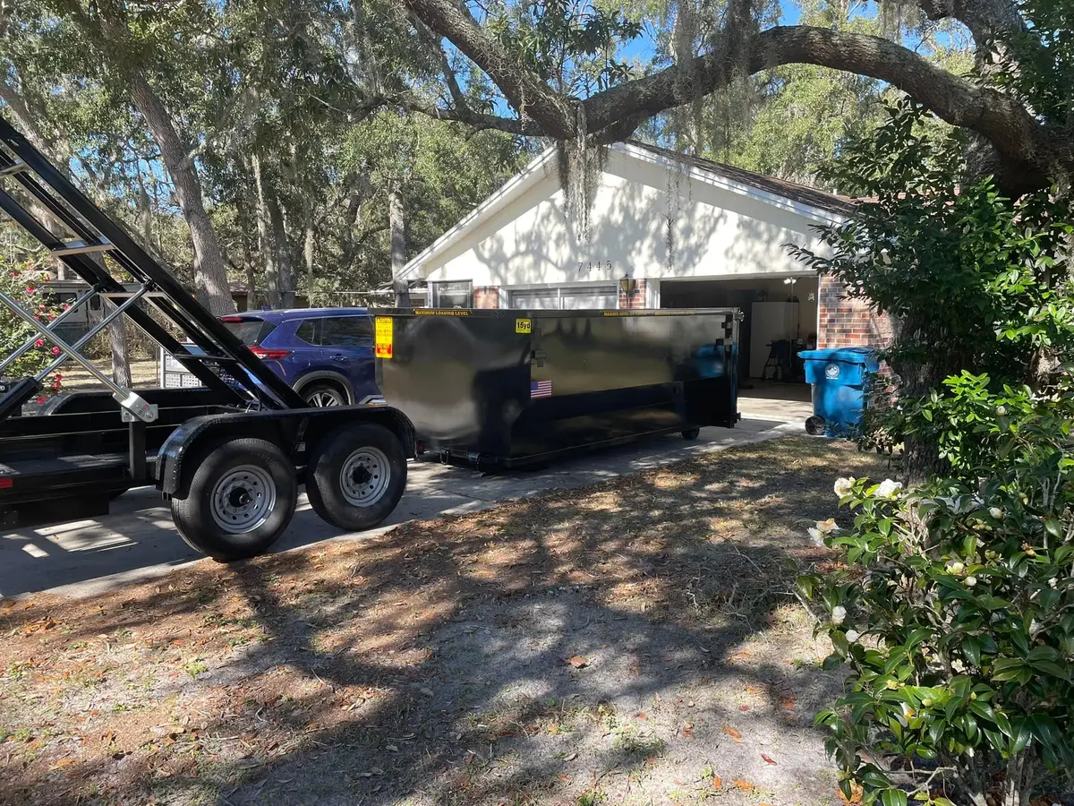Roll-off dumpster in front of a home ready for a roof tear-off