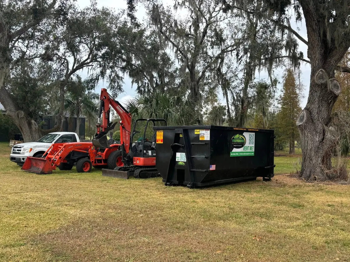 Black roll-off dumpster placed on a residential driveway in Winter Haven